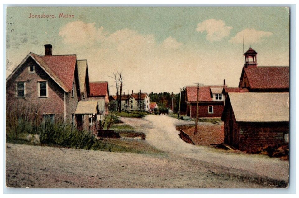 Hand-tinted postcard of a dirt road curving between red-roofed houses, with a building topped by a small bell cupola on the right.